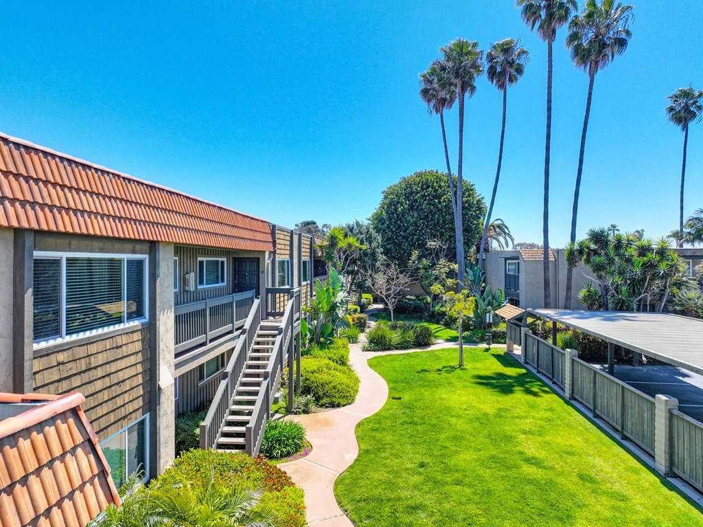 a building with a green yard and palm trees