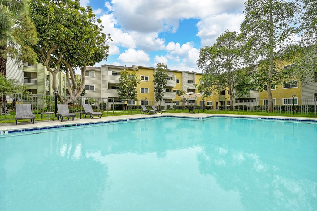 a swimming pool with an apartment building in the background