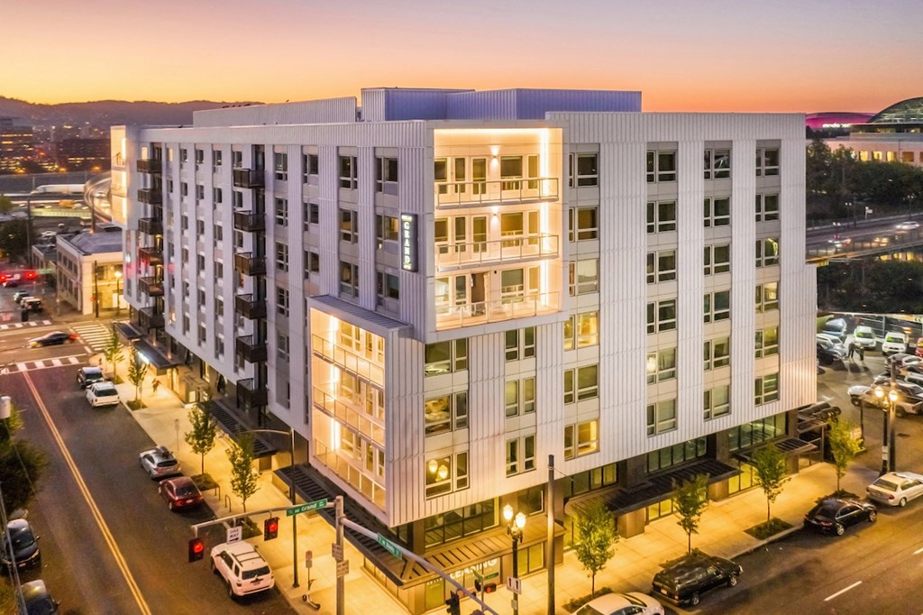 Elevated view of Skylar Grand community exterior at dusk with lighted balconies and street level