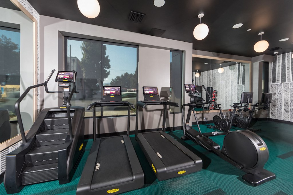 Resident gym with stairmaster, treadmills, seated bike, and elliptical machines.