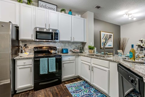 A kitchen with white cabinets and a black oven.