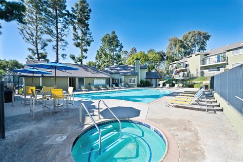 A swimming pool with a slide and sun loungers.