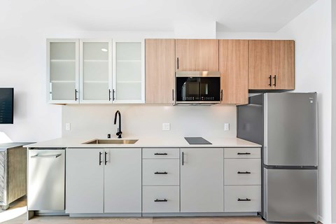 A modern kitchen with white cabinets and a stainless steel refrigerator.