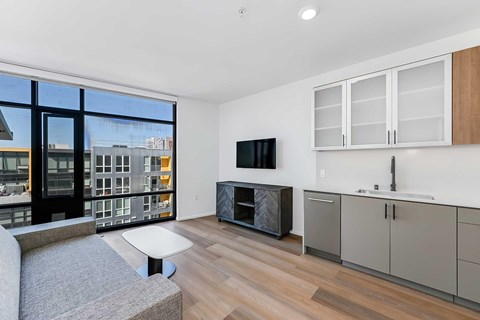 A modern living room with a grey sofa and a flat screen TV.