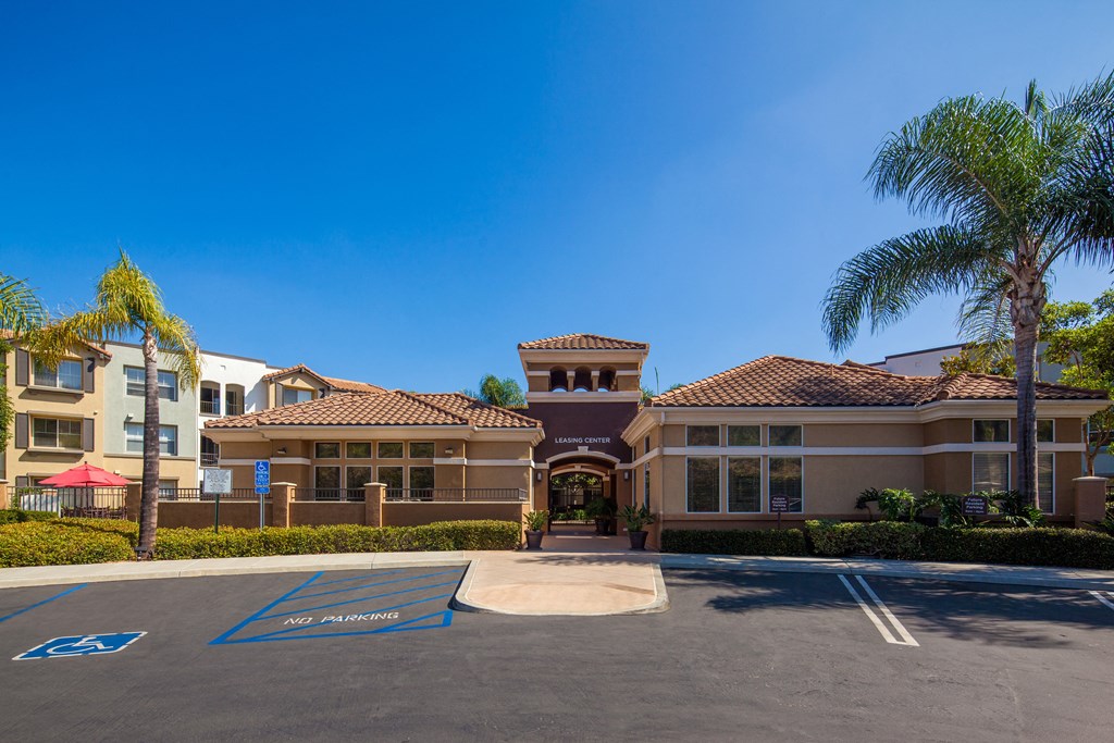 a building with a parking lot and palm trees in front of it
