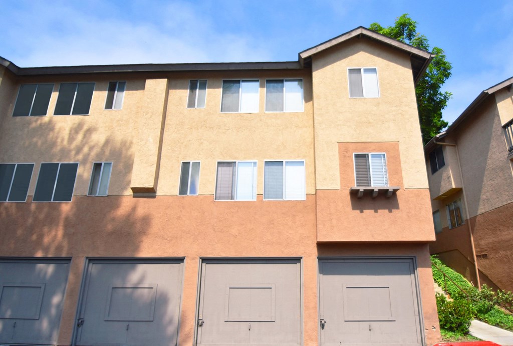 a building with a garage and a blue sky in the background