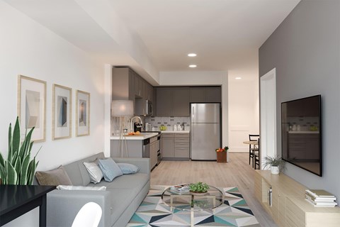 A modern living room with a grey couch and a glass coffee table.