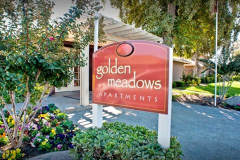 A sign for Golden Meadows Apartments.