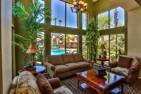 A living room with a pool view and a striped couch.