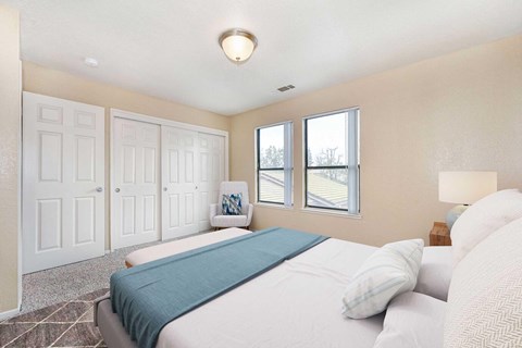 A bedroom carpet, off-white walls, and 2 windows. The room is staged with a bed, chair, a rug, and nightstand.