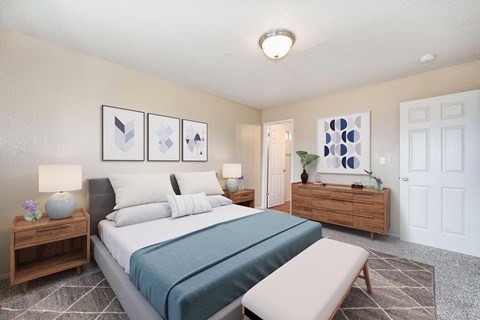 A bedroom carpet, off-white walls, and a bathroom connected. The room is staged with a bed, chair, a rug, and nightstand.