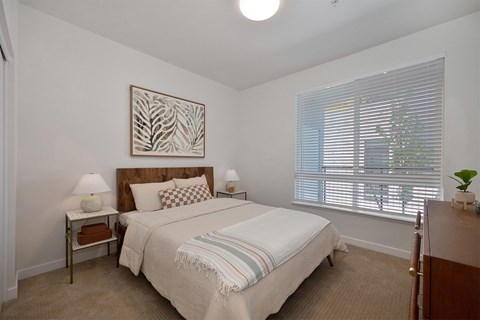 A bedroom with a large bed and a painting on the wall.