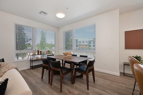 A dining room with a table and chairs.
