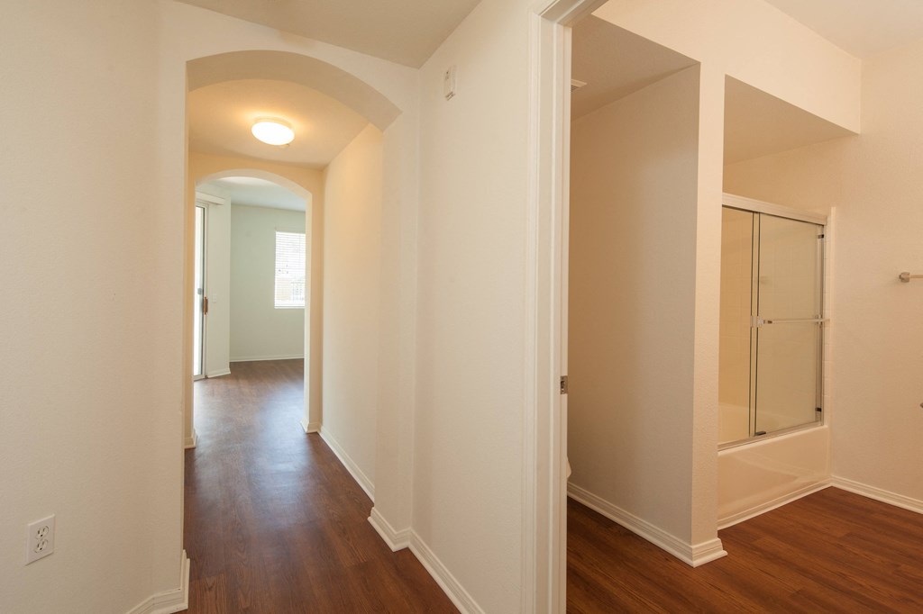 a bedroom with a hallway and a closet with a mirrored door