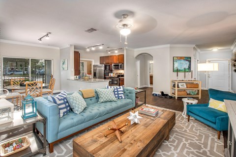 A living room with a blue couch and a wooden coffee table.