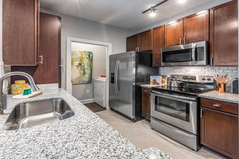 A kitchen with brown cabinets and stainless steel appliances.