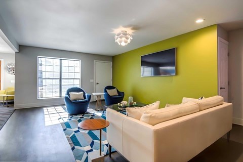 A living room with a white couch and a blue chair.