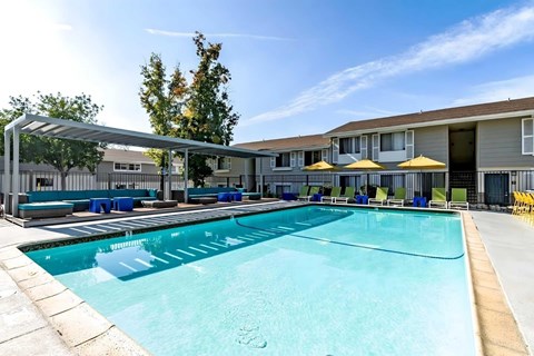 A large swimming pool with lounge chairs.