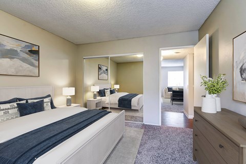 A bedroom with a large bed and a mirror.