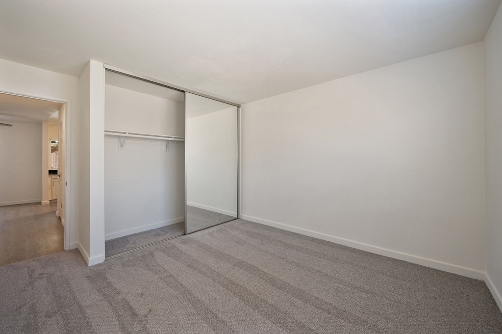an empty room with white walls and a closet