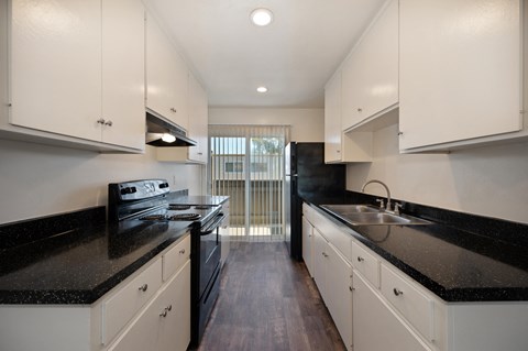 the preserve at ballantyne commons apartment kitchen with black counter tops and white cabinets