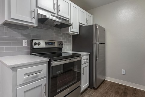 A kitchen with white cabinets and stainless steel appliances.