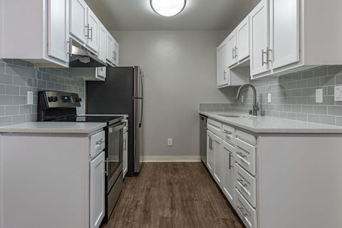 A kitchen with white cabinets and stainless steel appliances.