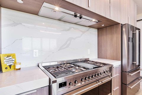 The stainless steel oven and fridge in the kitchen.