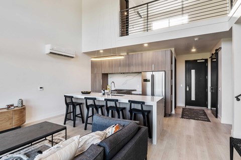 A modern kitchen with barstools up against the kitchen island.