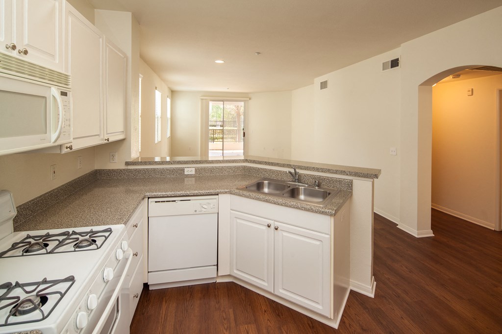 a kitchen with white appliances and granite counter tops