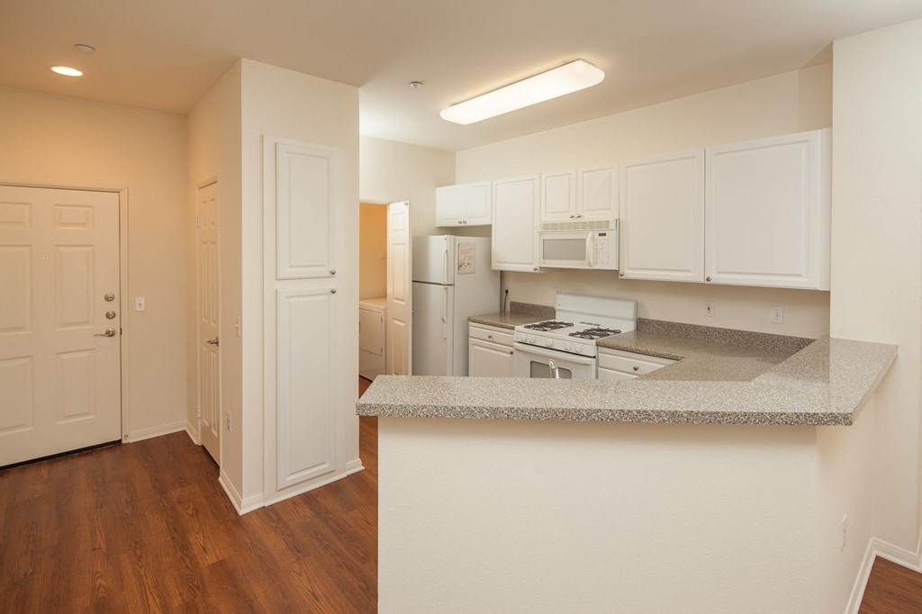 a kitchen with white appliances and a granite counter top