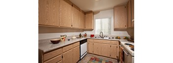 a kitchen with wooden cabinets and a white dishwasher