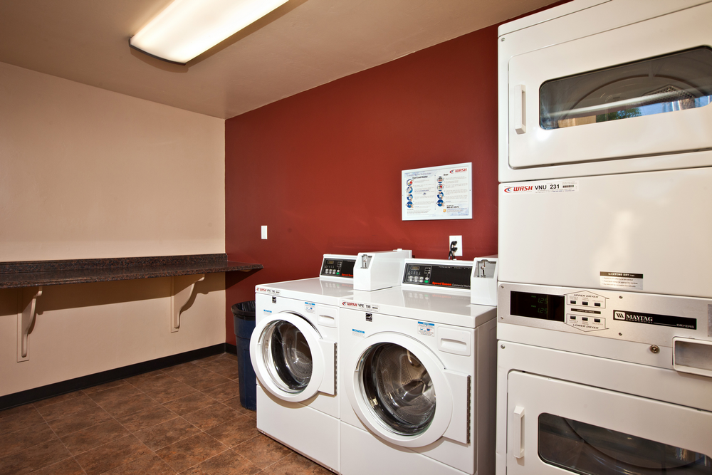 a laundry room with two washers and two dryers