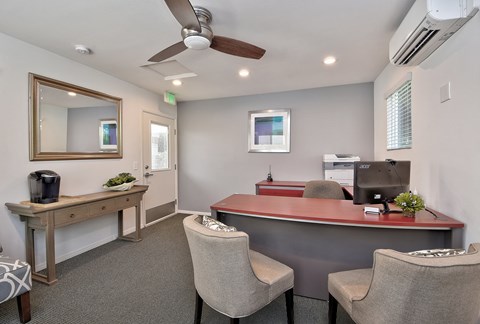 a office with a desk and chairs and a mirror