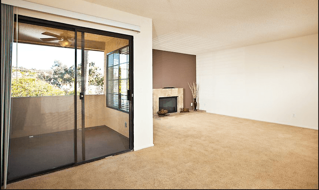 a living room with a fireplace and a sliding glass door