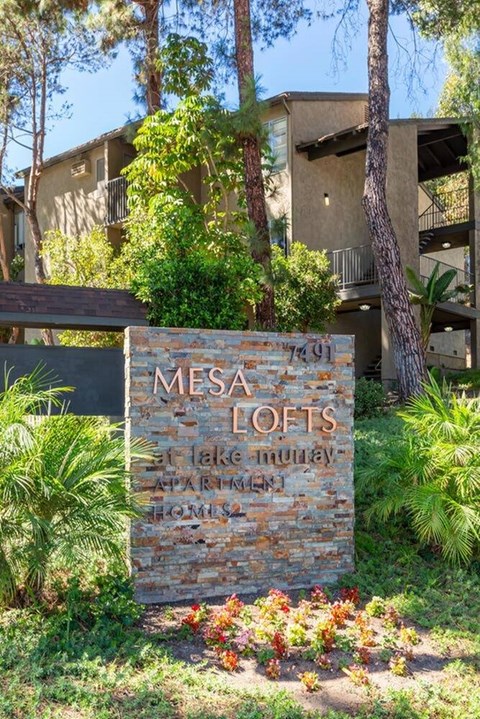 A sign for Mesa Lofts in front of a building.