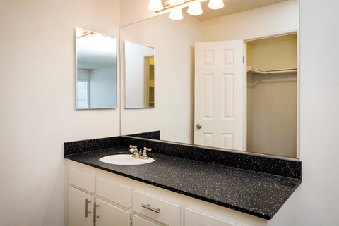 A bathroom with a sink and mirror.