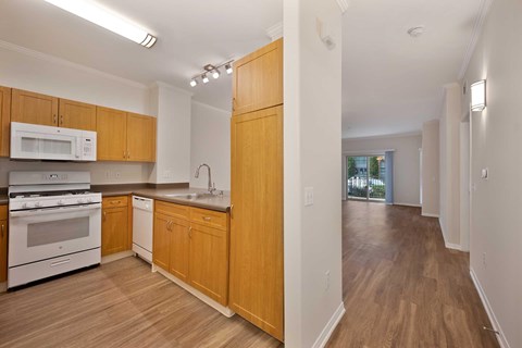 A kitchen with wooden cabinets and a white oven.