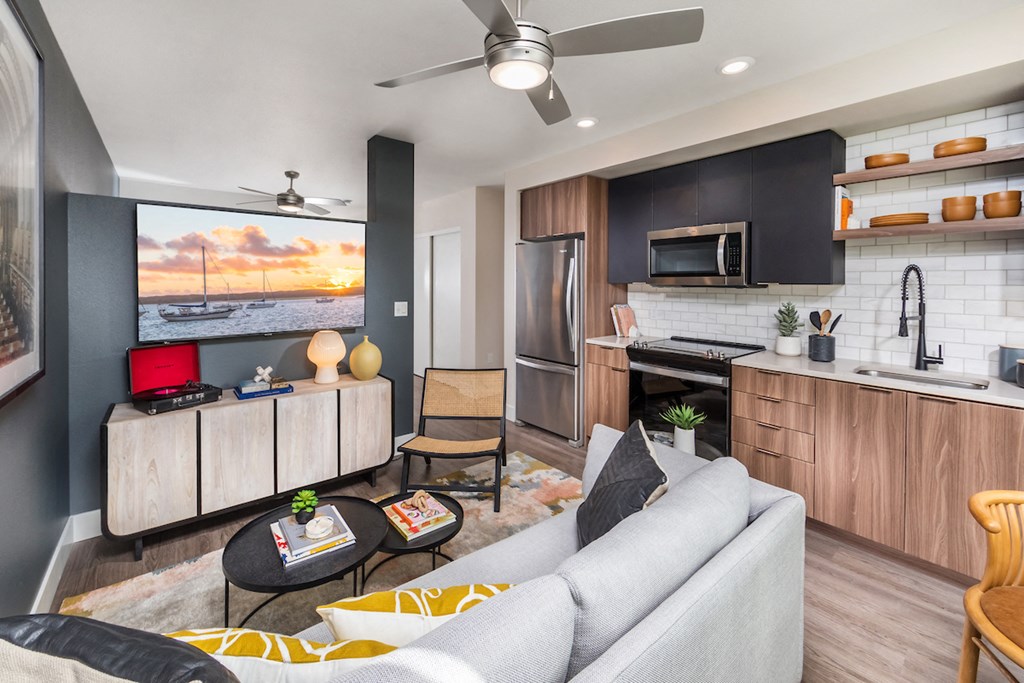 Brass design package living room with ceiling fans, wood style flooring, and stainless steel appliances