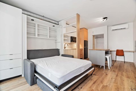 A bedroom with a bed, desk, and chair.