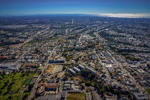 3 apartment buildings surrounded by roads from a high-up drone exterior view