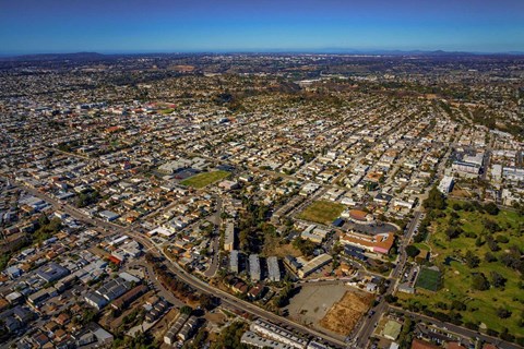 3 apartment buildings surrounded by roads from a high-up drone exterior view