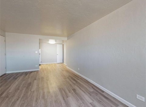A room with wooden flooring and white walls.