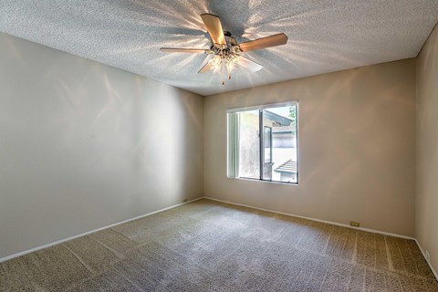 A room with a ceiling fan and a window.