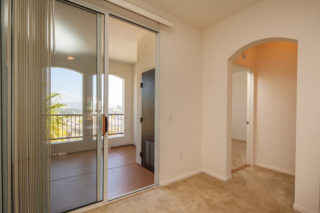 a living room with a large mirror and a balcony
