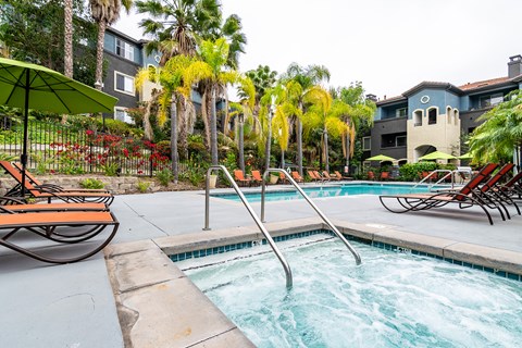 a close photo of a spa with resort-style pool and landscaping in the background