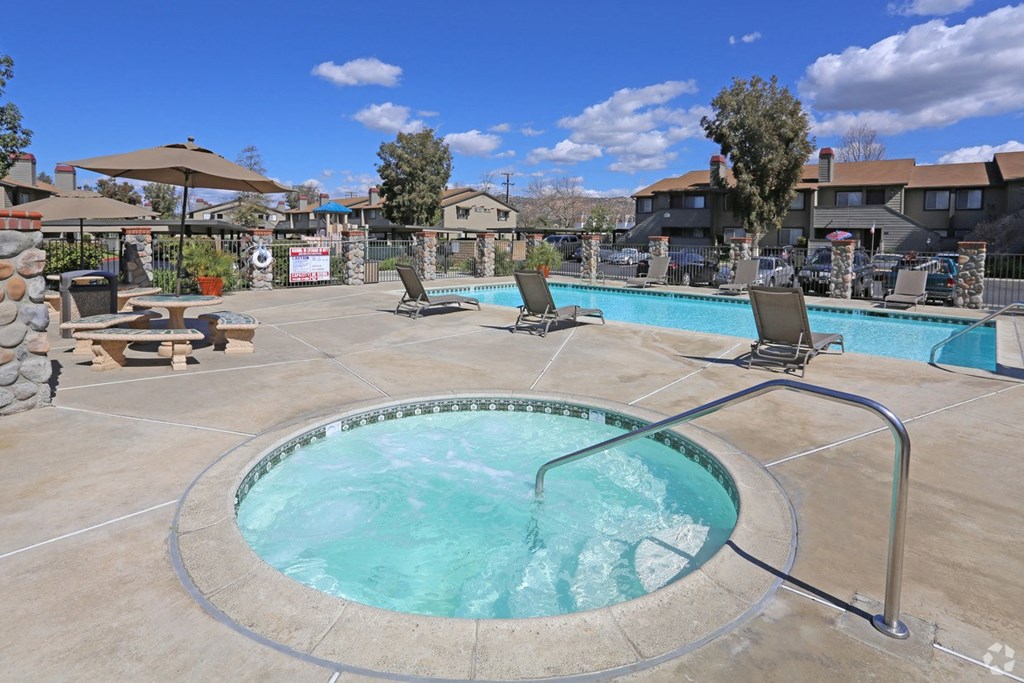 our apartments have a resort style pool with chairs and umbrellas