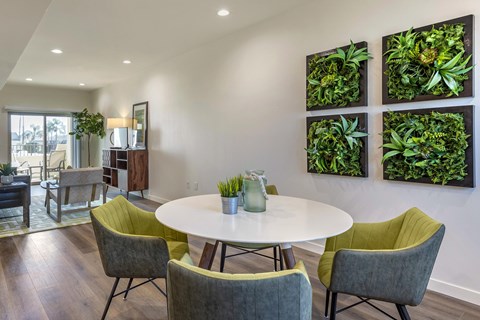 A dining room with a white table and green chairs.