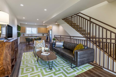 A living rom with vinyl flooring , stainless steel kitchen appliances, and a staircase leading to upstairs.