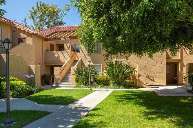 a building with stairs and a tree in front of it